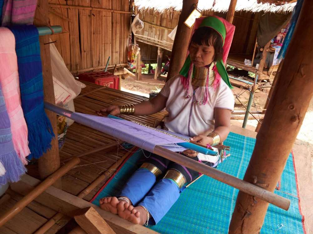 Une femme de la tribu des longs cous tisse à Chiang Rai